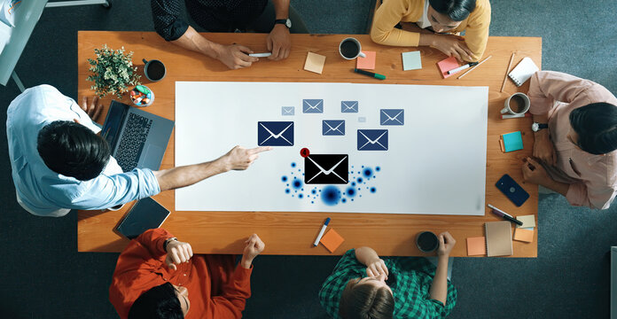 A dynamic workspace featuring a team engaged in collaboration. Digital elements related to email and communication enhance the creative atmosphere. Trope - Powered by Adobe