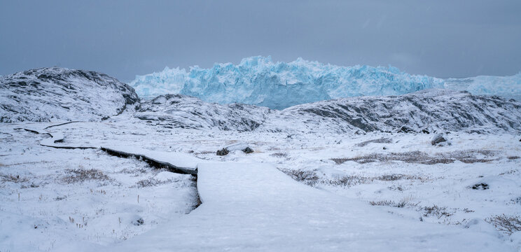 Giant icebergs floating in Ilulisat icefjord, Greenland. Massive icebergs, calved from the Sermeq Kujalleq Glacier, float through the Ilulissat Icefjord in western Greenland - Powered by Adobe