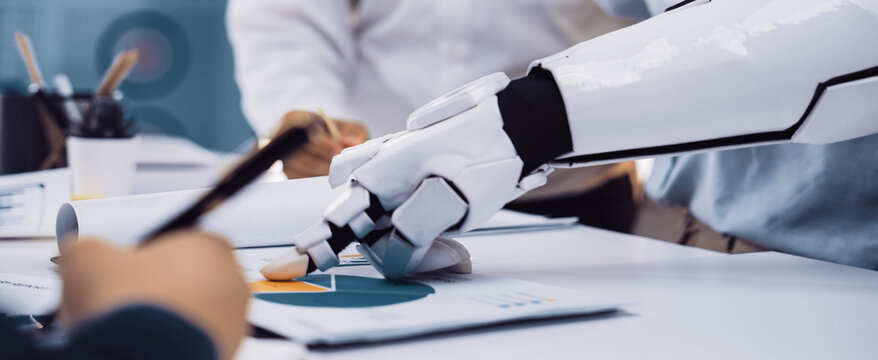A robotic arm actively engages in data analysis alongside business professionals in a modern office, showcasing the collaboration between technology and human intellect.Noogenesis