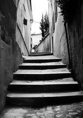 Black and white alleyway steps.  Narrow, descending stairway between aged buildings