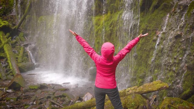 Woman hiker enjoying the view of the lush forest and moss at Proxy Falls in Oregon, USA.
