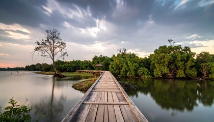 Scenic wooden bridge over tranquil water reflecting a dramatic cloudy sky scape