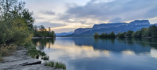 Tranquil lake reflecting a serene mountain vista at twilight