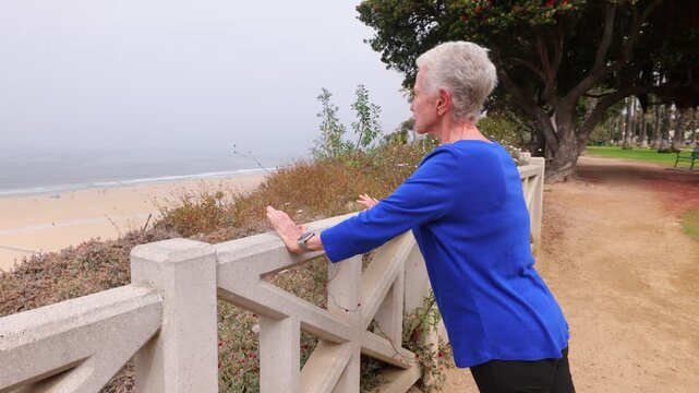 Senior woman gets her morning exercise at a park overlooking the Santa Monica beach.