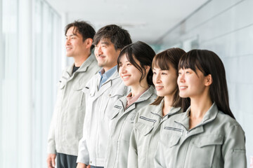 Obraz premium Male and female staff in the manufacturing, building, transportation and construction industries wearing work clothes 