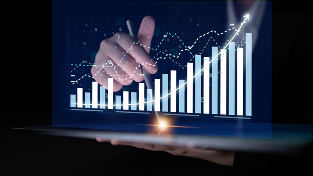 A close-up view of a hand interacting with financial data displayed on a tablet, showcasing growth trends and analytics for effective business decision-making. Impute