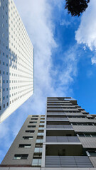 Fototapeta premium Looking up at the buildings of Yokohama under the blue sky.