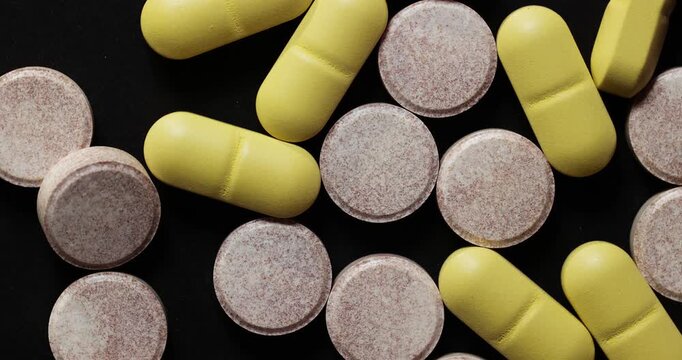 Drug pills spinning on a glowing tray