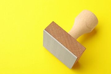 One wooden stamp on yellow background, closeup. Space for text
