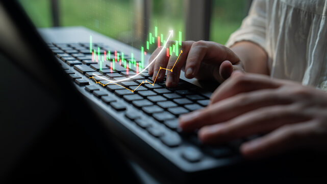 A focused individual engages in financial analysis, using a computer keyboard as a base for visualized data. The image captures modern business dynamics and investment strategies. Impute