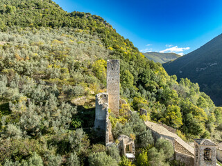 Aerial view of Umbria's Hidden Hilltop medieval castle ruin with square keep and round tower in Monterivoso
