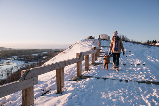 Woman and toddler walking down big steps at Bowmont Park on a clear Wintry day