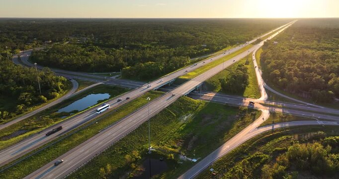 Wide multilane expressway crossroad with overpass ramps and flowing traffic in rural American landscape