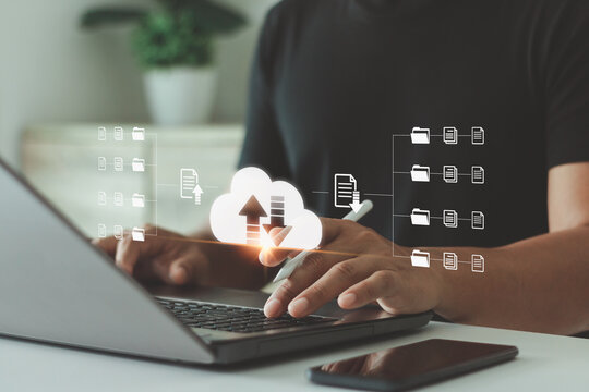 Businessman using laptop with digital cloud storage interface, data upload and file sharing system for online business. Concept of cloud computing, data management and technology innovation.