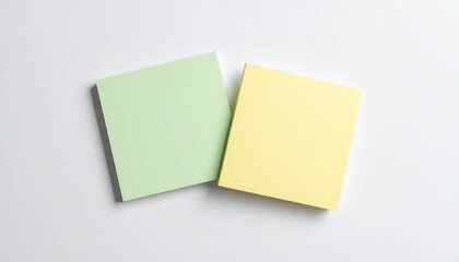 Two blank sticky notes, green and yellow, on a clean white background, perfect for reminders, messages, or office concepts.