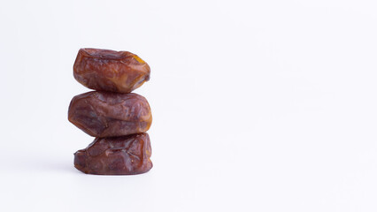 Stacked Sukkari Dates on White with Copy Space. Minimalist concept for healthy Ramadan food, Iftar, or gourmet advertising.
