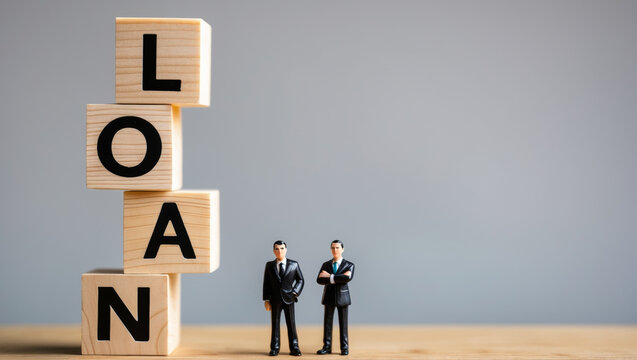 Business and finance concept showing wooden blocks forming loan with two miniature businessmen in suits.