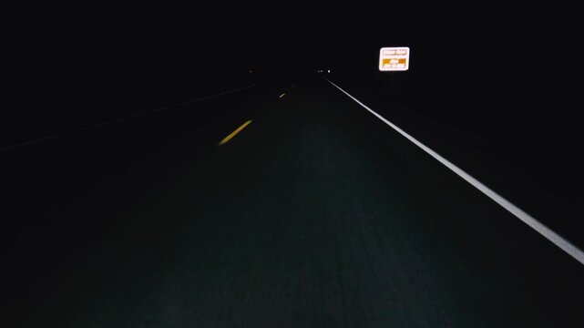 POV in the car, driving on a dark empty road, highway in the middle of the night