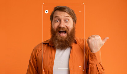 A man with a thick beard is smiling widely while pointing his thumb up. He wears a bright orange...