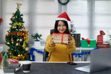 Happy asian young woman typing an email on laptop on Christmas at home.