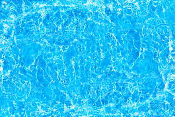 Blue water with ripples on the surface. Defocus blurred transparent blue colored clear calm water surface texture with splashes and bubbles. Water waves with shining pattern texture background.