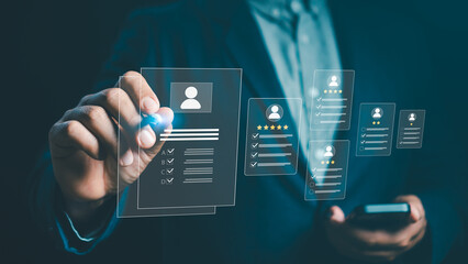 Businessman using digital interface to evaluate employee profiles and performance rating system. Concept of HR technology, recruitment, data analysis, and human resources management.