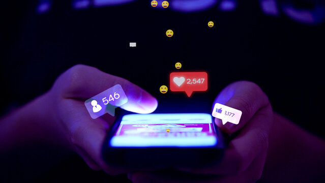 Close-up of hands holding a smartphone, scrolling social media with glowing icons for likes, followers, and comments; concept of digital engagement and influencer.