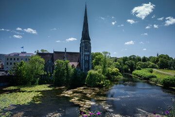 Fototapeta premium Anglican church of St. Alban’s stands peacefully beside a lake and trees in Copenhagen.