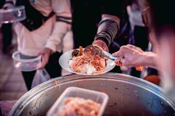 The hands of the hungry get food from the hands of volunteers, Food Donations for Homeless