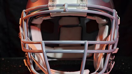 rotating silver football helmet with orange glow, detailed studio shot | sport, equipment, design, technology, american football theme - Powered by Adobe