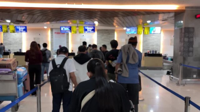 Passengers queue to board a plane at the airport terminal. Blur video.
