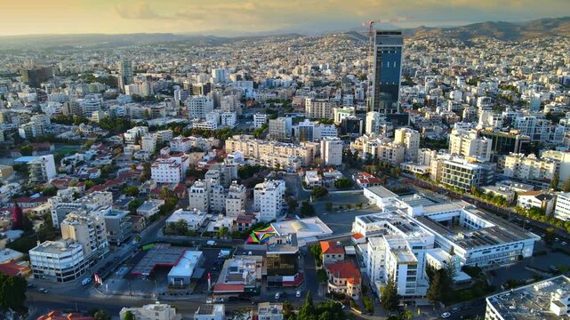 Aerial panoramic view of Limassol, Cyprus, highlighting the modern skyline, residential areas, and green spaces. The image captures the vibrant city life, urban development.