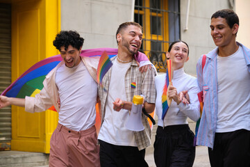 Group of young people happily walking together, celebrating LGBTQ plus pride with flags