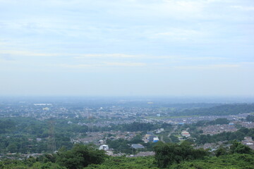 Panoramic City View with Lush Green Hills