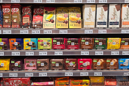 Kuala Lumpur, Malaysia &ndash; Sep 14, 2025: A wide selection of chocolate bars displayed on shelves at Jaya Grocer, featuring brands such as KitKat, Ritter Sport, Belgian Chocolate and durian chocolate.