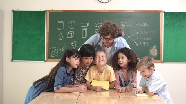Caucasian smart teacher and diverse student looking at camera at classroom. Group of happy children smiling while instructor hug to encourage and standing in front of black board. Education. Pedagogy.