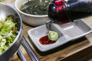Pour Korean soy sauce into a bowl with wasabi