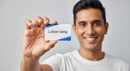 A smiling man holding a name tag with the text 'Laban lang' in front of a plain background