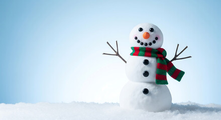 Happy smiling snowman wearing a festive scarf standing in the snow on a blue winter background with copy space