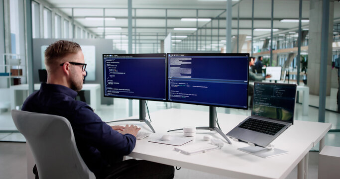 Young Programmer Man Coding Software On Desktop Computer - Powered by Adobe