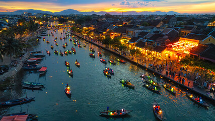 Aerial view of Hoi An ancient town along the Thu Bon River in Vietnam. Tourists ride long-tail...