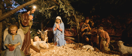 Fototapeta premium Santons de la nativité dans la crèche de Noël, faite en matière naturelle, format bannière