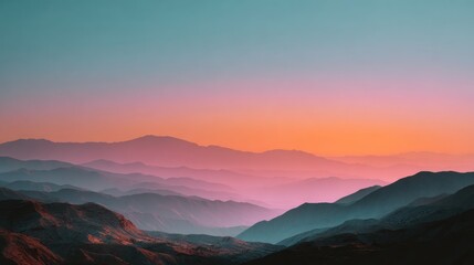 Gradient sky above multiple layered mountain peaks bathed in vibrant sunset hues