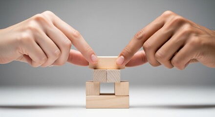 Diverse hands collaborating to build a stable wooden block structure
