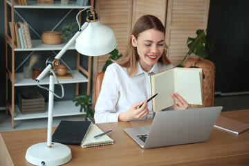 Young woman with notebook having job interview online at home
