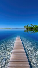 Wooden Dock Extends Into Crystal Clear Turquoise Tropical Ocean Under Bright Blue Sky with Small Island Lined with Palm Trees in the Distance
