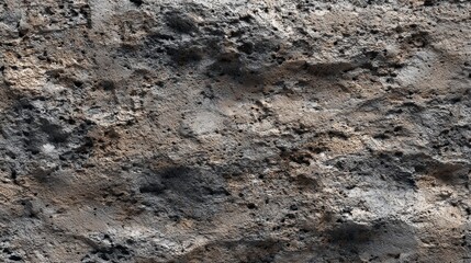 Naklejka premium A textured surface showcasing a rough, uneven stone or concrete material with dark and light variations.