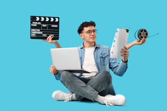 Male screenwriter writing scenario and female hands holding movie clapper with film reel on blue background