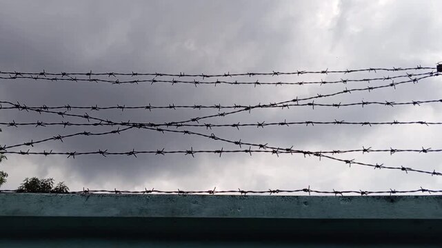 barbed wire fence with cloud background