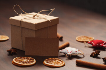 Christmas gift box from eco friendly paper wrapped with natural twine on wood table with natural decorations and 2021 card